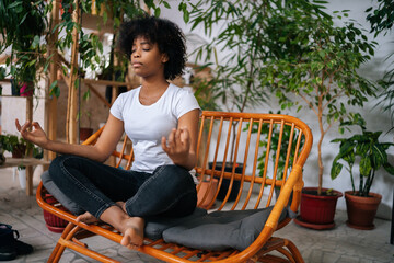 image of woman sitting in char doing yoga/ calming exercise.