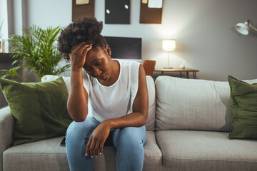 Image of woman sitting on sofa depressed